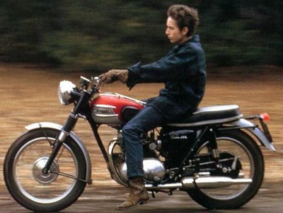 bob dylan riding motorcycle action shot on road 