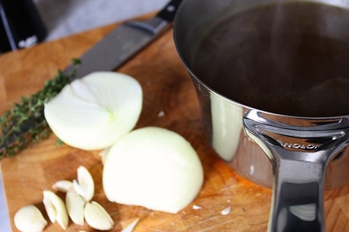 Bring 8 cups of beef stock, remaining garlic, onion, and 4 sprigs of thyme to a slow simmer over medium heat.