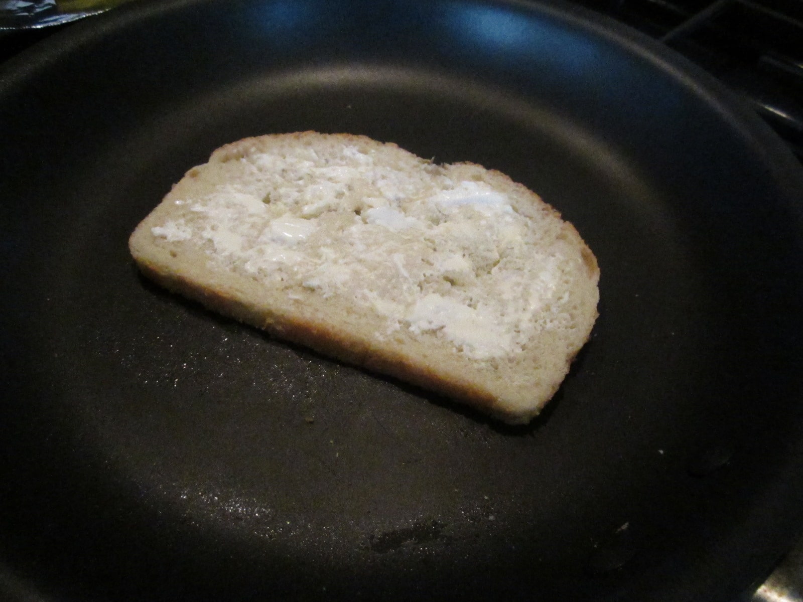 Butter one side of each piece of bread just like you would for a normal grilled cheese. Slap it down on the skillet and spread cream cheese on the side facing up to you.