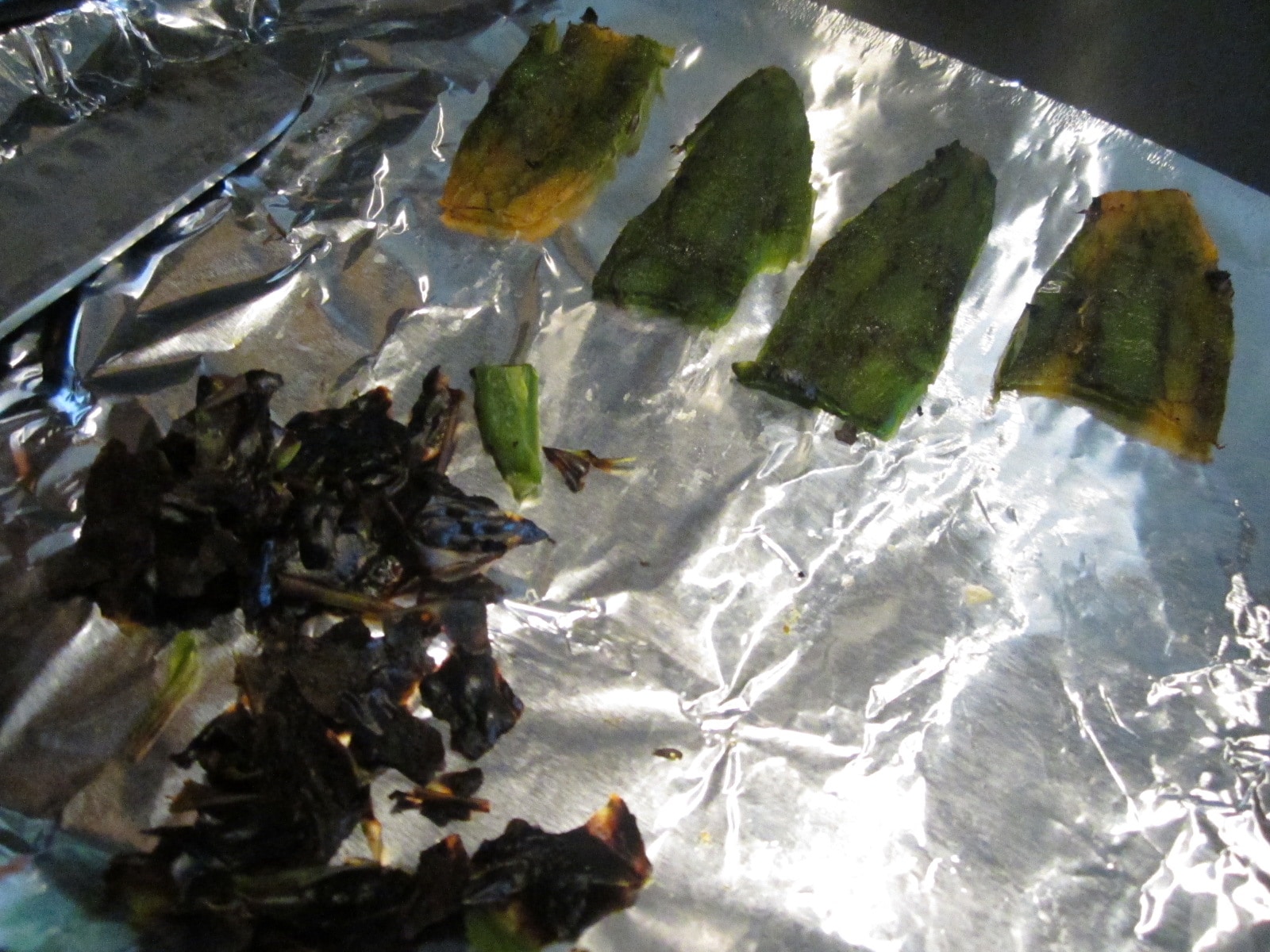 Put the cut jalapenos on tin foil on a baking sheet. Place under broiler for ~5 minutes. I allowed them to steam for a few minutes underneath a bowl so the skin would loosen up. Then peel the skin with a knife. It's easier than I expected to roast jalapenos.