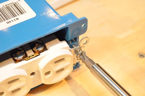Carefully maneuver all the wires into the box and attach the receptacle with the two screws.
