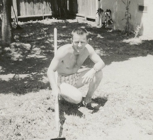 vintage man with garden hoe working on lawn yard 