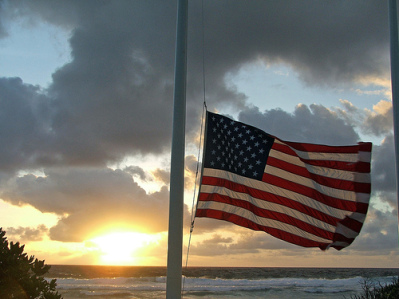 Old Glory, a symbol of respect and patriotism, soars high above the majestic ocean waves.