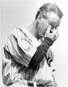 A black and white photo of a baseball player in a state of distress, with his hand on his face as he contemplates the game.