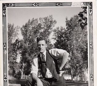 A man displaying true manliness as he leans confidently on a bench.