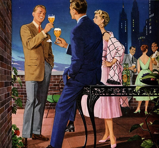 A man and woman are elegantly dressed, drinking wine on a balcony overlooking a wedding celebration.