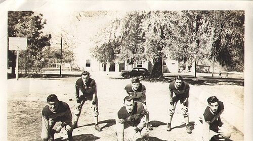 A group of men participating in gut-busting conditioning drills on the gridiron as they pose for a photo.