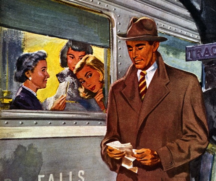 A man in a hat and coat is standing next to a train, looking like a million bucks.
