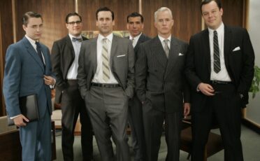 A group of Mad Men in suits posing for a picture, showcasing their manly haircuts.