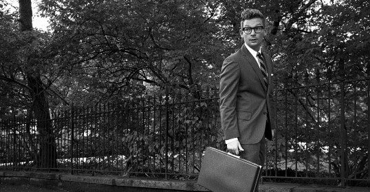 A man in a suit walking with a briefcase embodies the rules of the Art of Manliness.