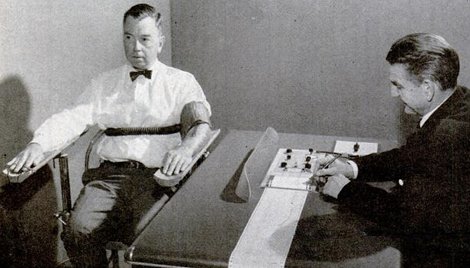 A man sitting at a desk in an old photo, seemingly capable of sniffing out lies.