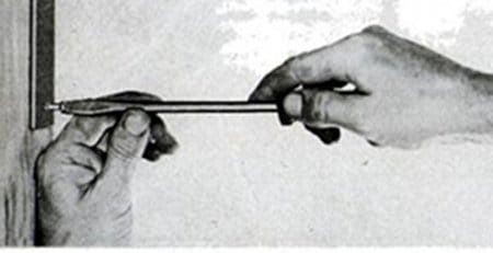 A person is using a screwdriver to open a door, showcasing their skill in toolmanship.