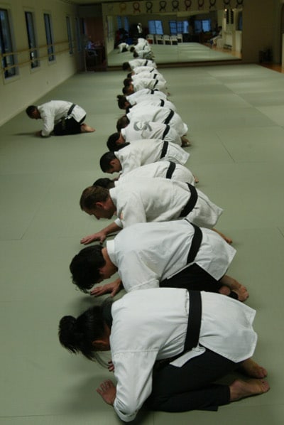 A group of Martial Artists kneeling down in a karate room.