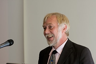 A man in a suit and tie delivering a speech.