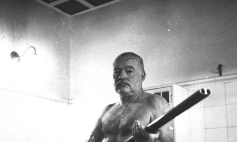 A man with a gun in a bathroom, channeling Ernest Hemingway.