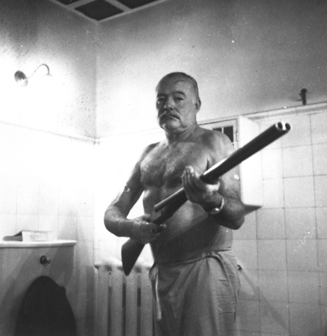 A man with a gun in a bathroom, channeling Ernest Hemingway.