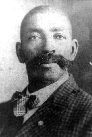 An old photo of a man with a mustache that exudes manliness.