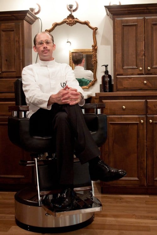 A barber working on a customer in a barber shop.