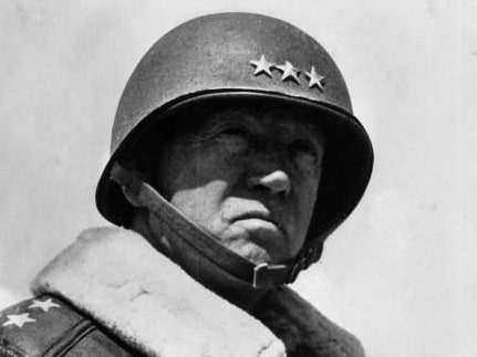 A black and white photo of a man in a military uniform, possibly General George S. Patton.