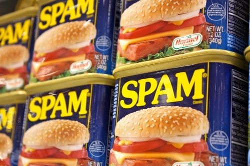 A low-cost can of spam sits on a shelf.