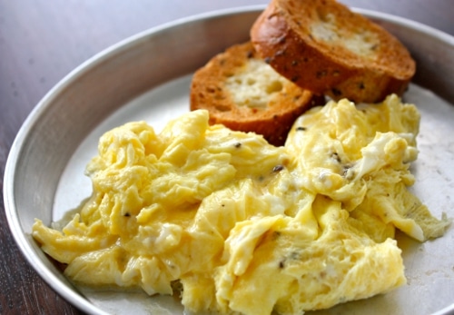Scrambled eggs on a plate with bread, a perfect breakfast basic.
