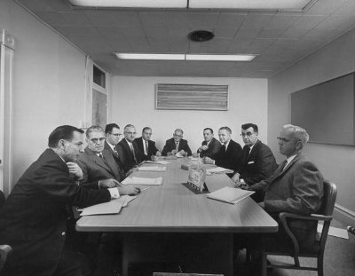 A group of men pitching ideas around a conference table.