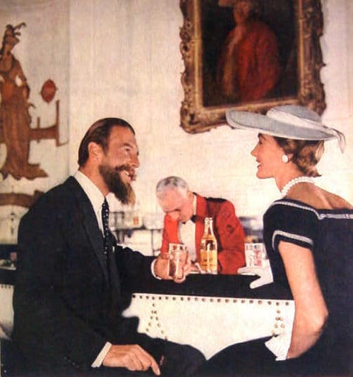 A characteristics man and woman sitting at a table talking.