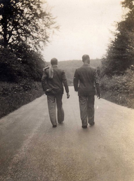 Two men grieving for their deceased friend walk down a country road.