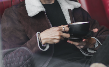 A woman holding a cup of coffee.