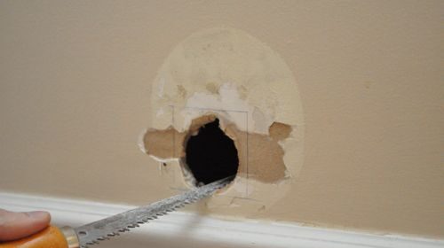 A person patching a hole in a drywall.