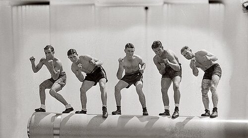 A group of men posing on top of a ship during a military fighter drill.