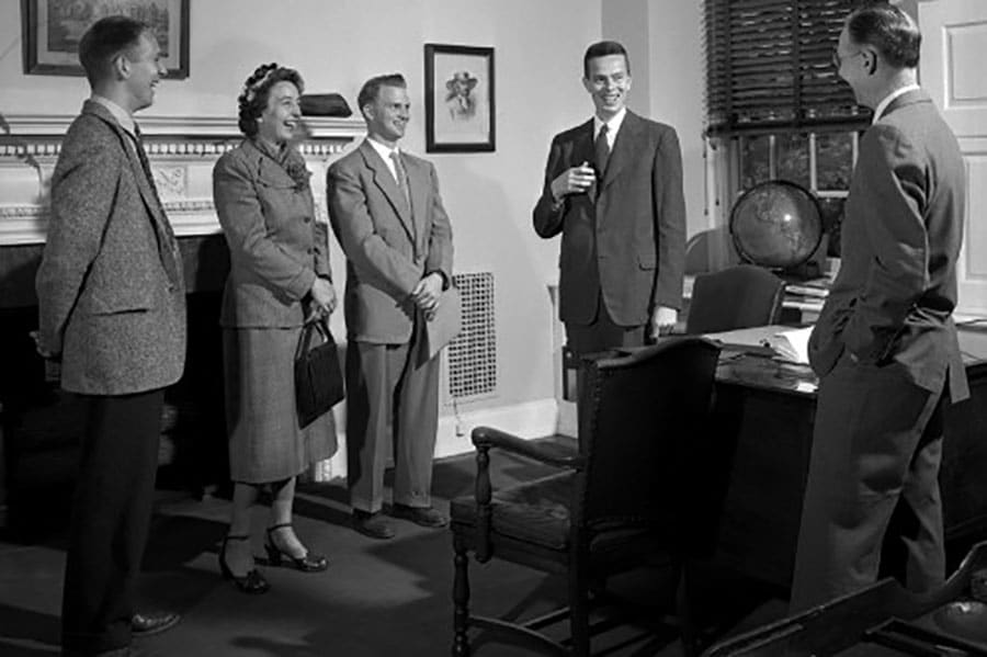 How small talk helps a group of people standing in front of a desk.