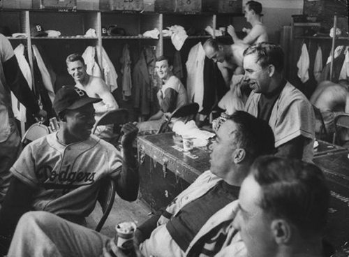 A group of men, baseball players, in a locker.