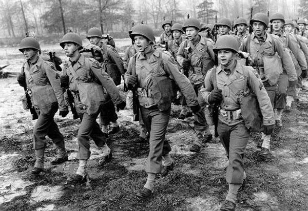 A group of soldiers confidently undertaking a 20 Mile March through a field.