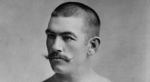 A black and white photo of a man with a mustache showcasing his masculinity.