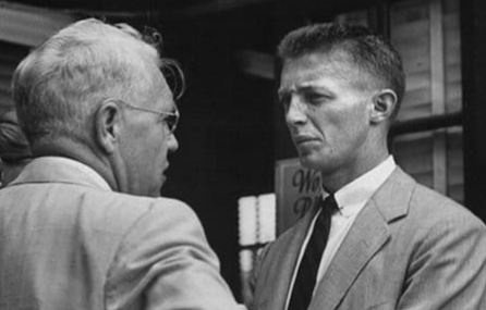 Two men in suits having a conversation.