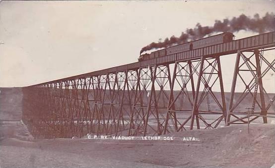 An old photo capturing the art of a train traveling over a bridge.