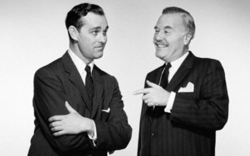 Two men in suits, confidently accepting a compliment.