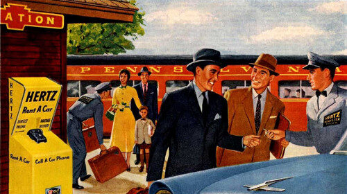 A man in a suit is standing next to a rented car.
