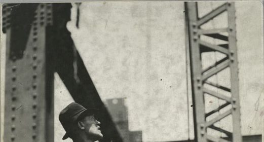 A man exhibiting strength and majesty as he stands on an old bridge.