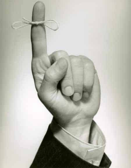 A black and white photo of a hand holding a string, showcasing the strength it imparts.