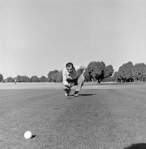 An old black and white photo of a man putting a golf ball, highlighting his strength.