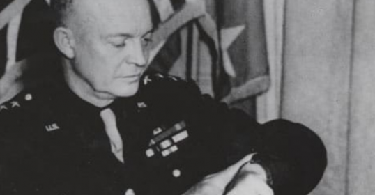 A man in a military uniform is holding an important watch.