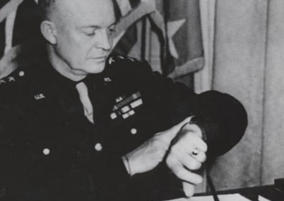 A man in a military uniform is holding an important watch.