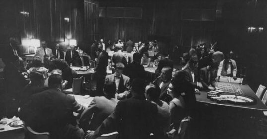 A black and white photo capturing a group of professional gamblers in a room.