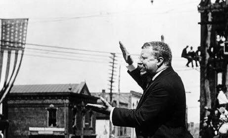 A man in a suit giving a speech to a crowd, making history.