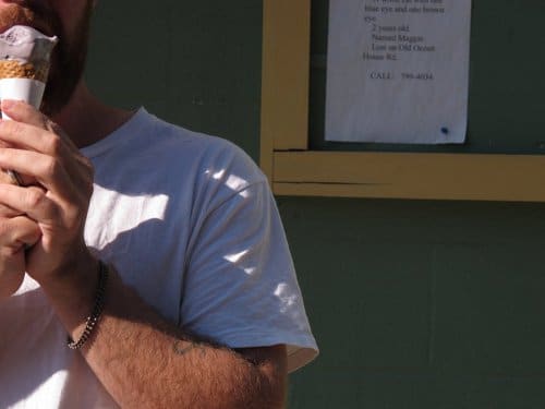 A bearded restaurant critic enjoying an ice cream cone.