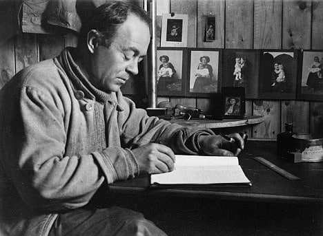 A challenging black and white jumpstart photo of a man journaling at a desk.