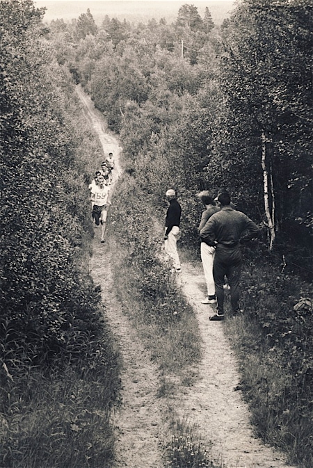 A group of people Ditch the Pavement as they walk down a dirt path.