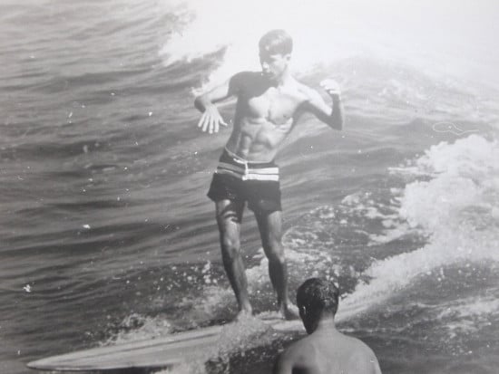 A man is riding a wave on a surfboard, embracing the thrill of living life to the limits as he Hack Your Flow.